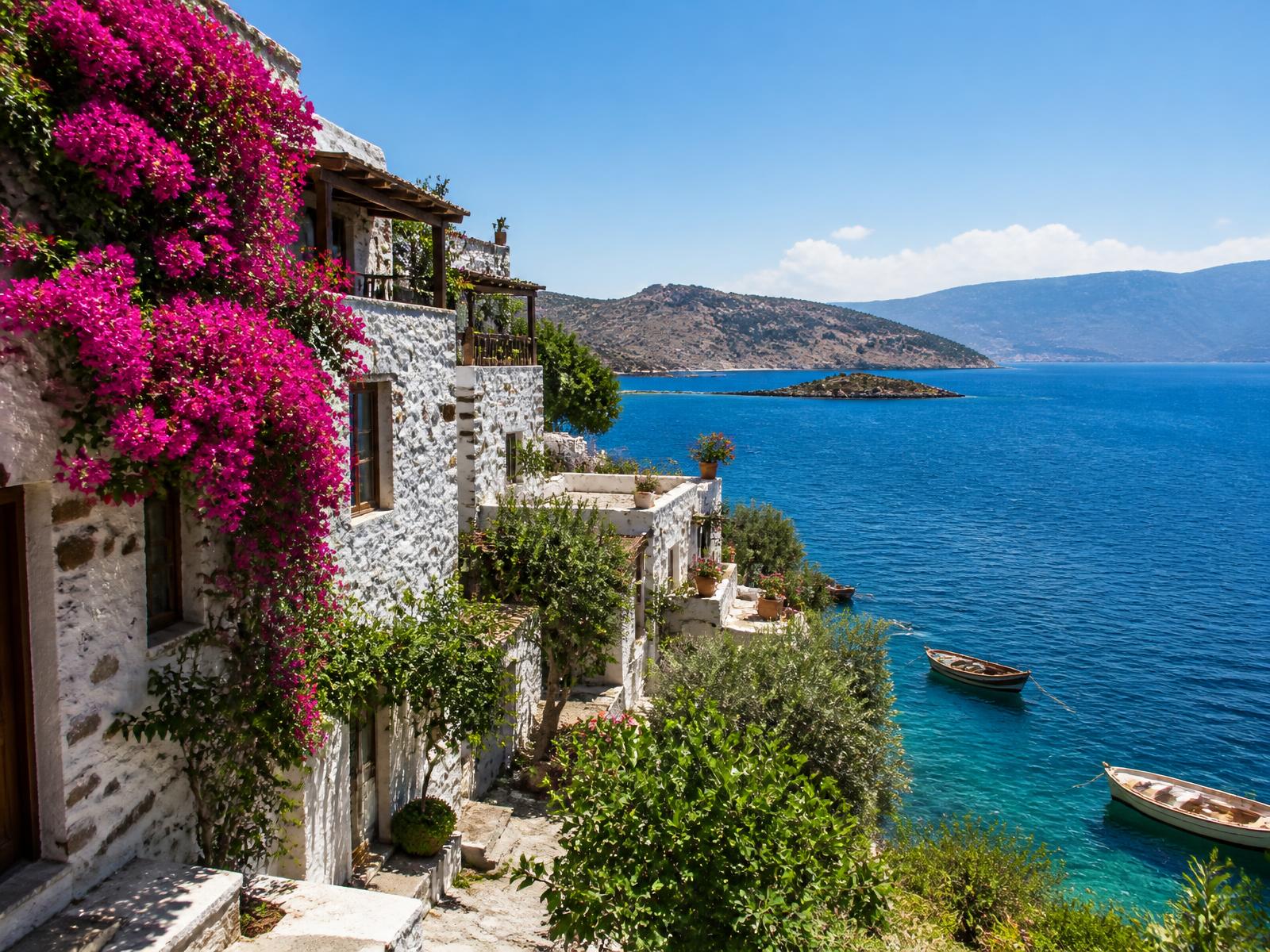 Whitewashed stone houses above an Aegean bay