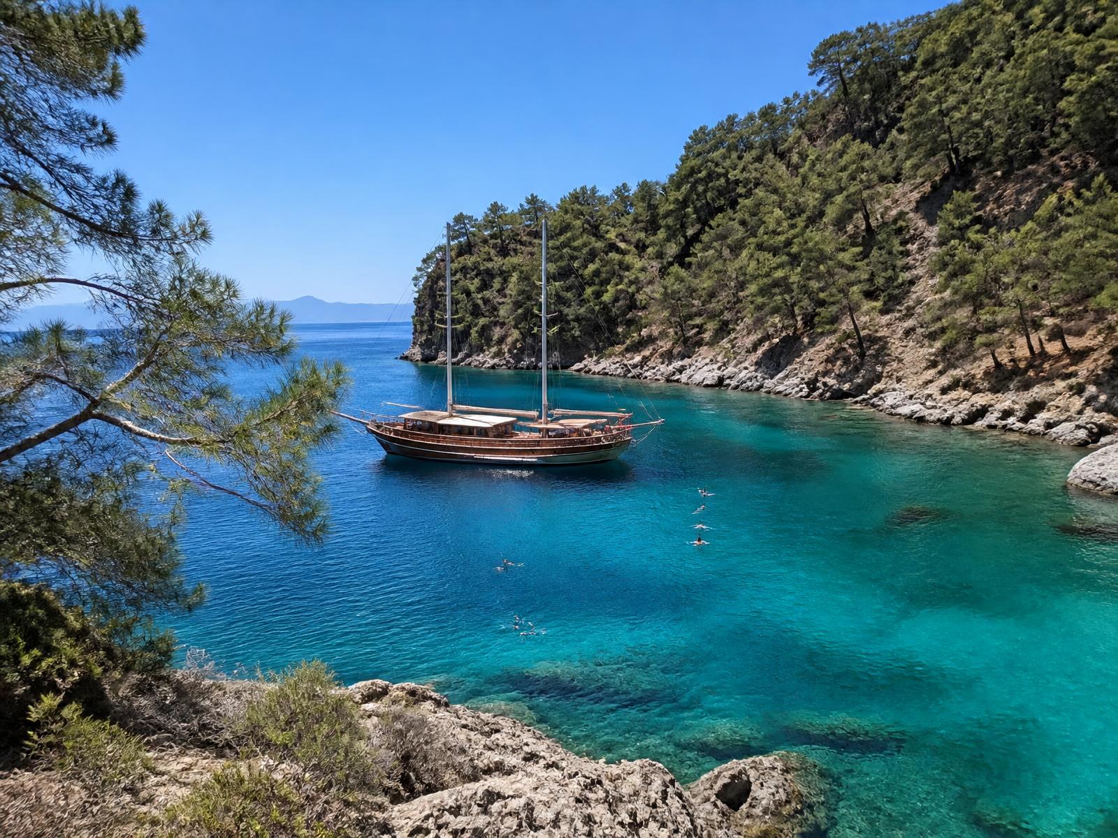 A wooden gulet anchored in a turquoise cove near Göcek