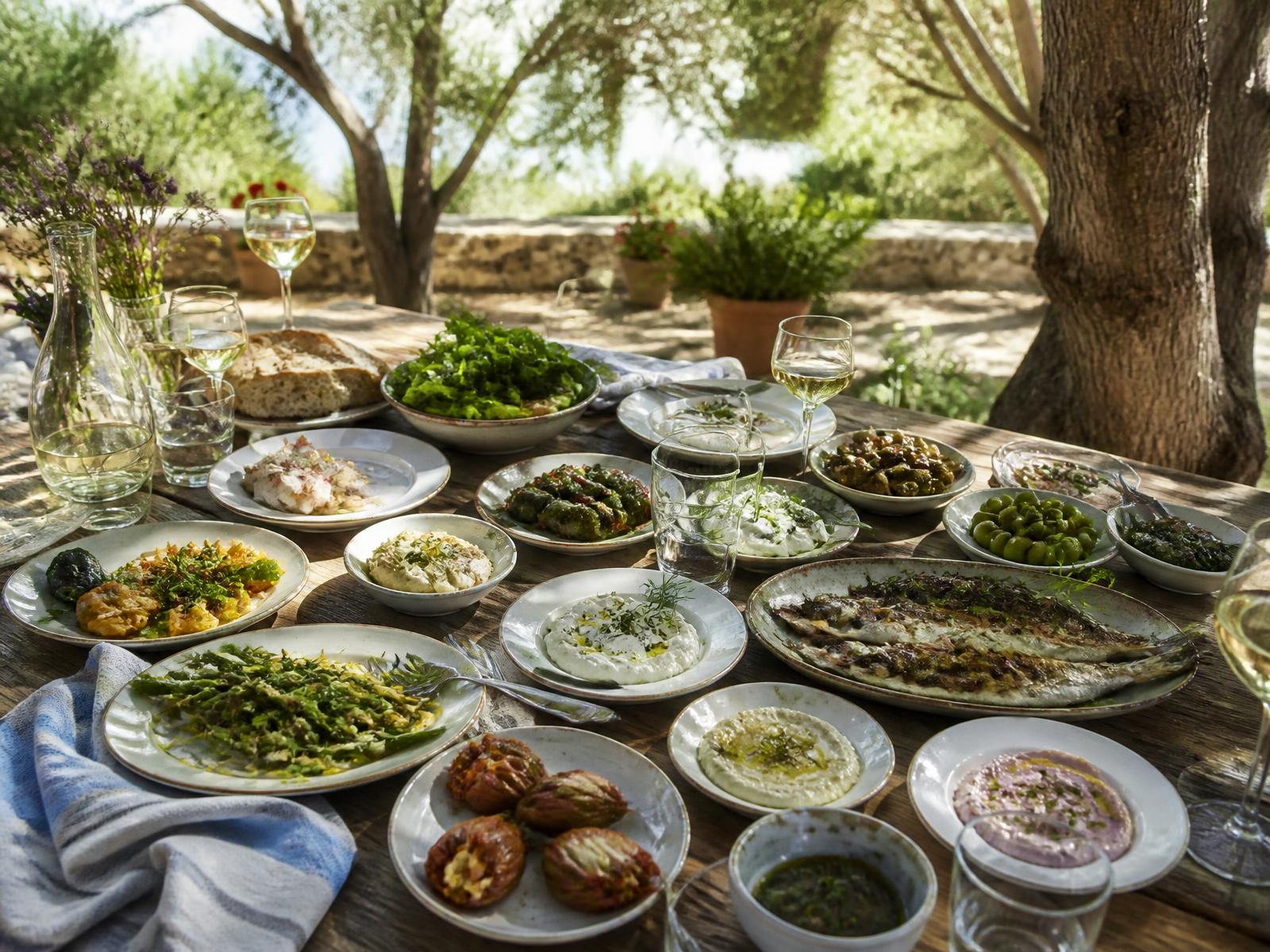 An Aegean table of small dishes under olive trees in Urla